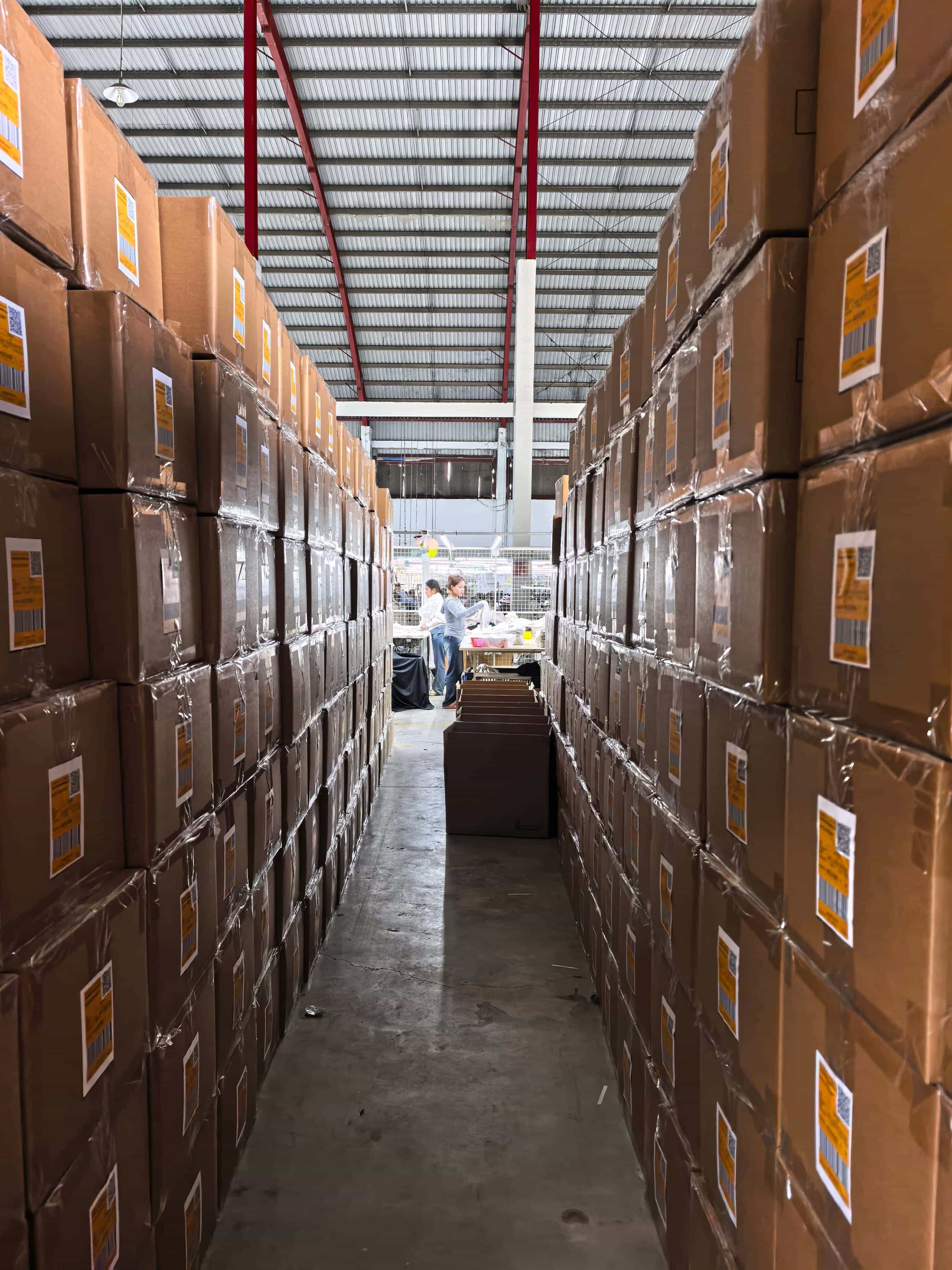 Warehouse aisle with packed apparel cartons at Cambodia garment factory