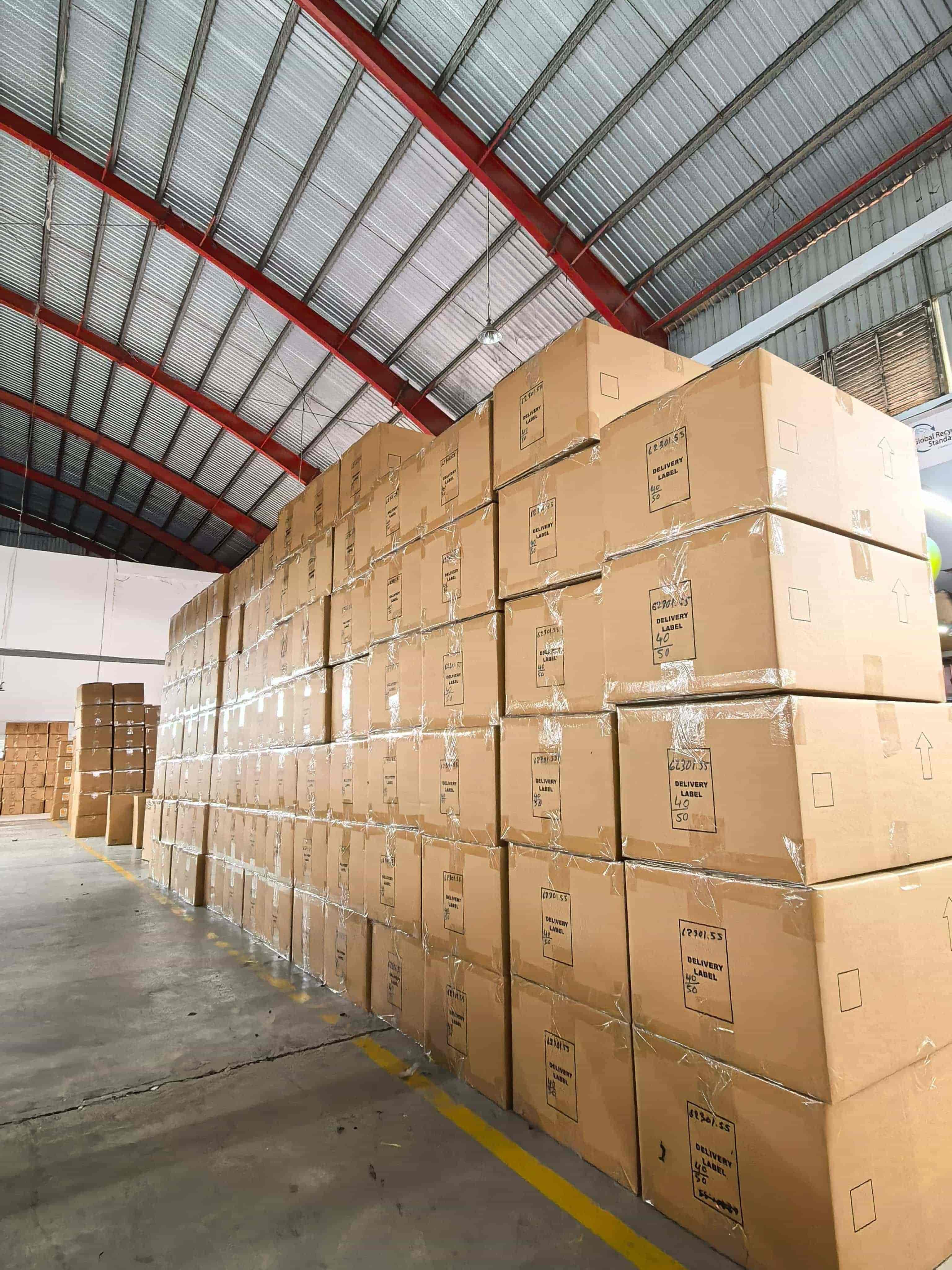 Packed garment cartons stacked in Southeast Asia apparel factory warehouse