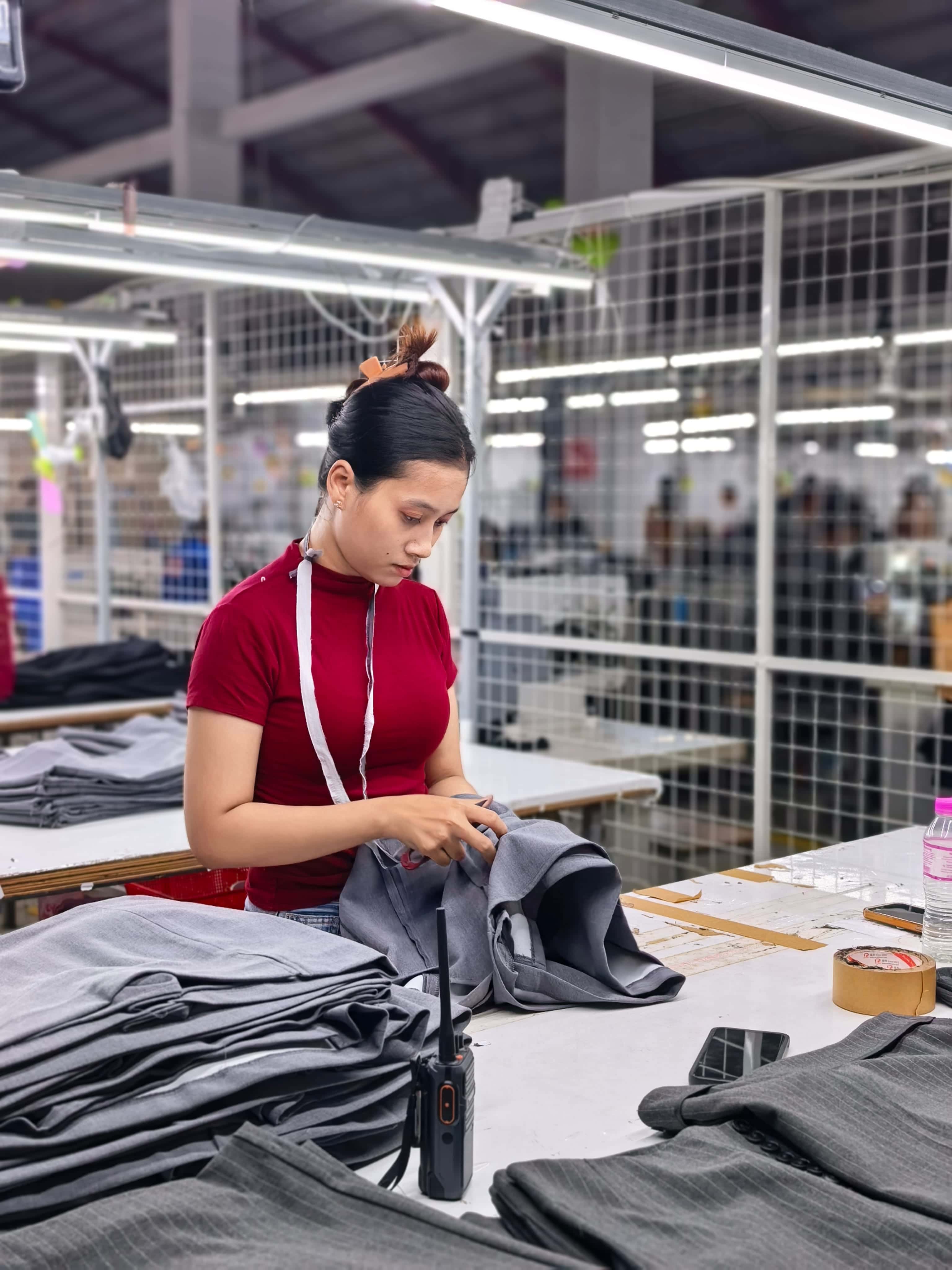 Worker checking garments at Southeast Asia apparel factory