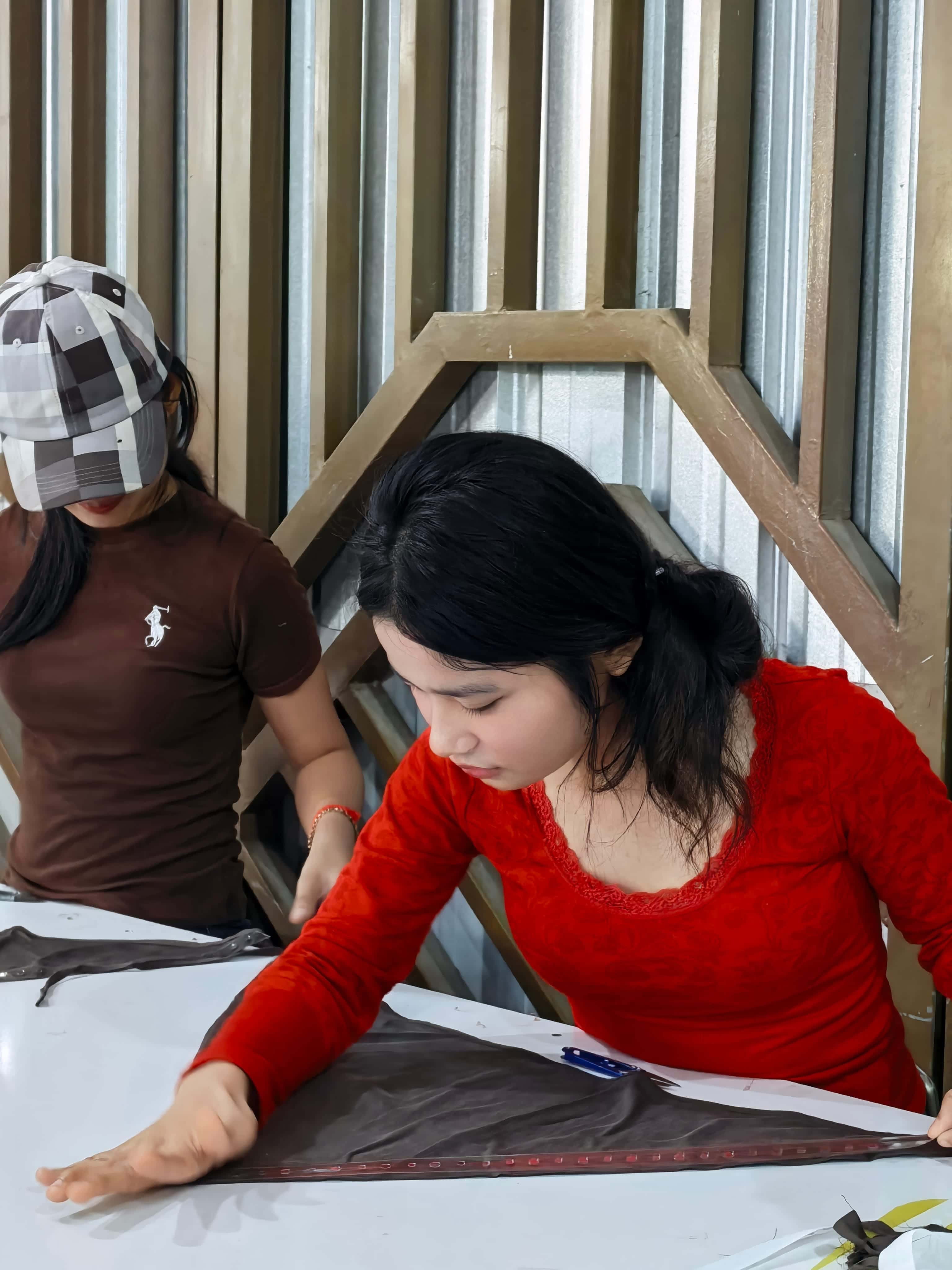 Cambodia garment factory workers reviewing finished apparel
