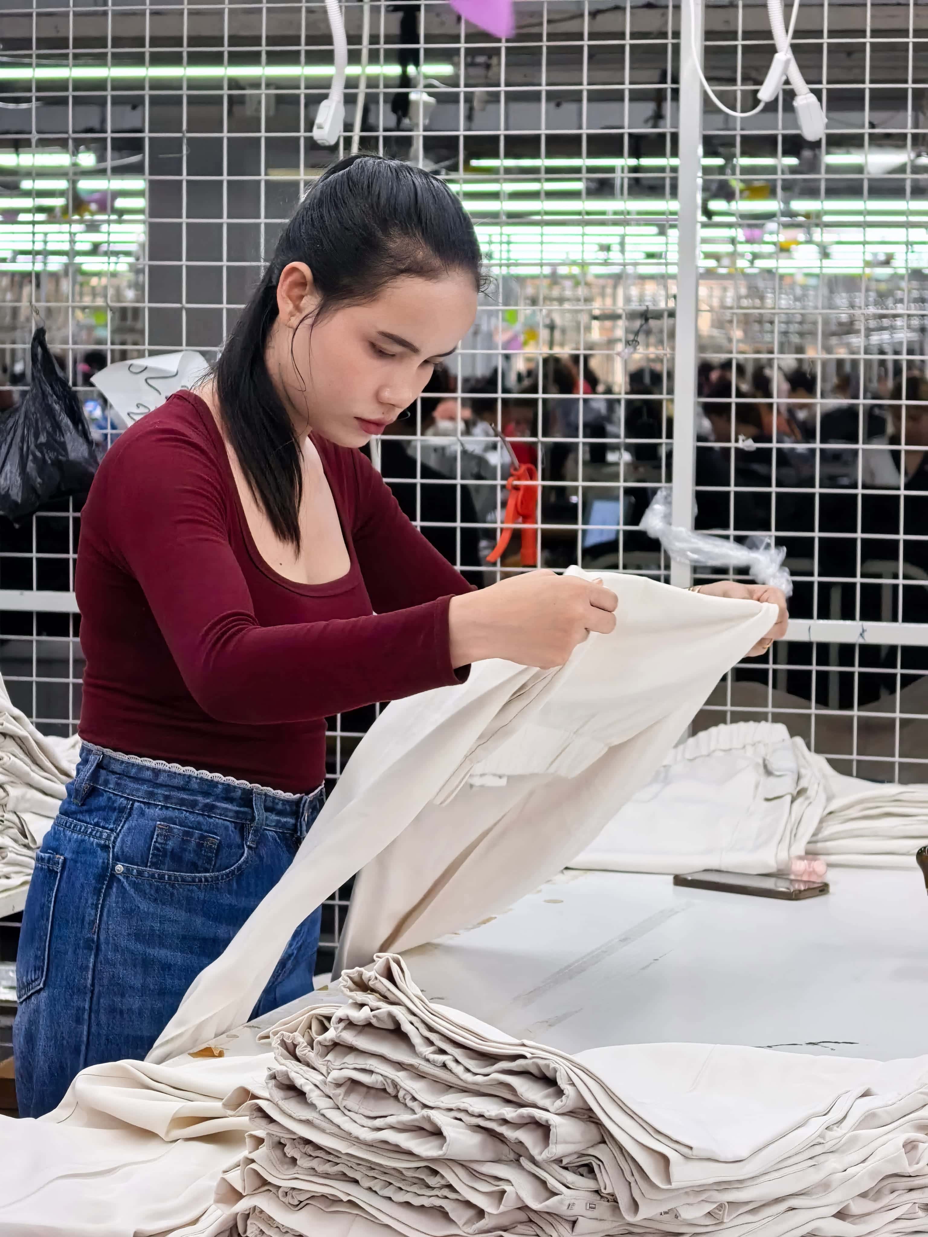 Apparel worker inspecting garments in Cambodia production facility