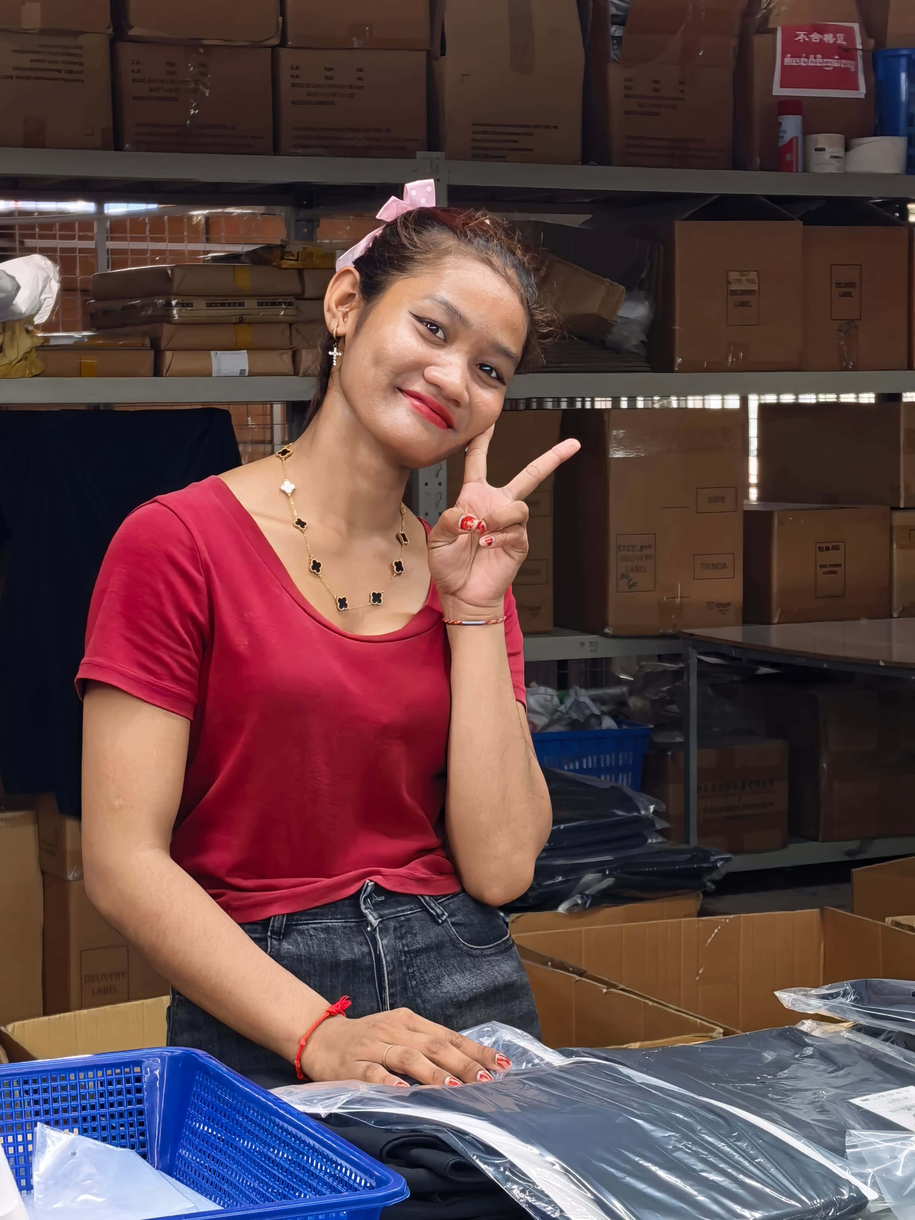 Factory team member packing apparel for production orders